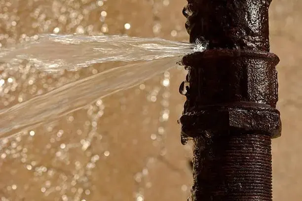 Water spraying from a split, corroded supply pipe